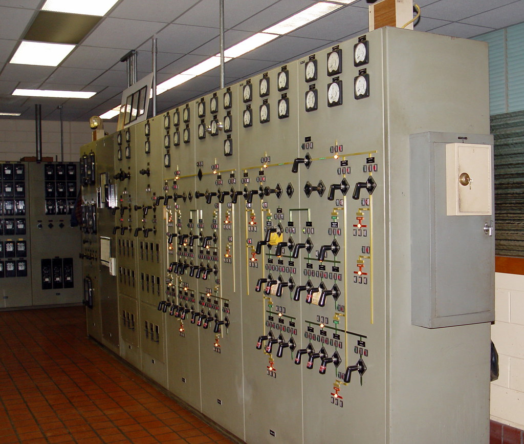 A long row of electrical control panels carrying instruments, switches and indicator lamps.